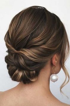 a woman's hair in a low bun with pearls on the top and side