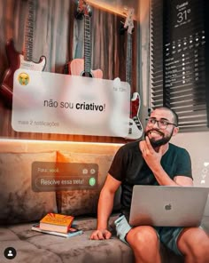 a man sitting on top of a couch with a laptop computer in front of him