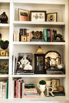 a white book shelf filled with books and figurines on top of each shelf