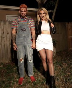 a man and woman standing next to each other in front of a house at night