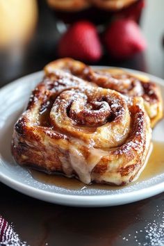 two cinnamon rolls sitting on top of a white plate