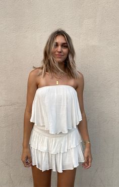 The Monaco White Strapless Romper is a vacay dream! White woven rayon fabric falls from a strapless neckline, with no-slip strips, to a flowy, ruffle overlay bodice with an on-trend smocked overlap back detail. Attached shorts complete the look. Bohemian Sleeveless Tube Top For Vacation, White Strapless Tube Top With Ruffles, White Strapless Ruffled Tube Top, White Ruffled Strapless Tube Top, Strapless Summer Tube Top With Smocked Back, Bohemian Strapless Tube Top For Beach, Summer Strapless Tube Top With Smocked Back, Strapless Tube Top With Smocked Back For Summer, Strapless Smocked Back Tube Top For Summer