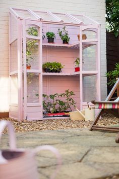 a pink shelf filled with potted plants next to a lawn chair