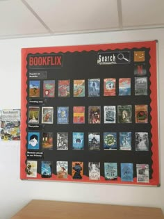 a bulletin board with books on it in an office space next to a wooden table