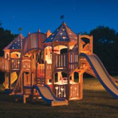 a children's wooden playset with slide and climbing frame in the night time