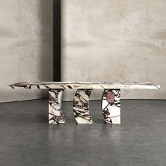 a marble table sitting on top of a floor next to a gray wall and cement walls