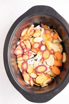 a bowl filled with lots of different types of food next to a white table top