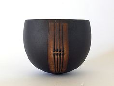 a black and brown bowl sitting on top of a white table