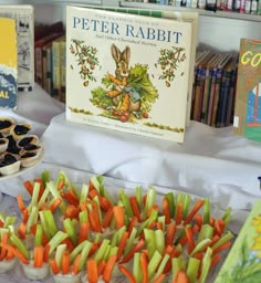 there are many different foods on display at the table and in front of them is a book about peter rabbit