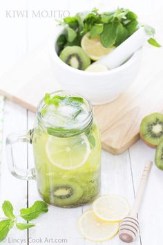 a mason jar filled with sliced kiwis and lime slices next to a cutting board