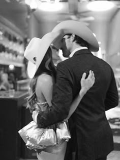 a man in a cowboy hat kissing a woman