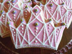 some pink and white decorated cookies on a glass plate with a basket in the background