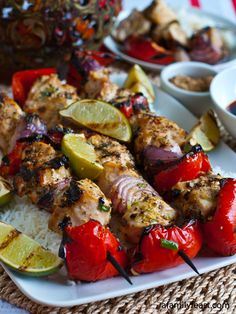 chicken kabobs on skewers with rice and limes