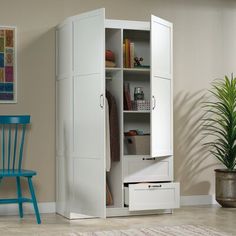 an armoire with two doors and drawers next to a blue chair in a room