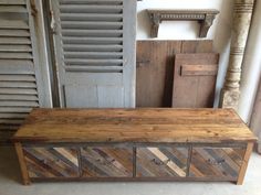 a wooden bench sitting next to some shutters in a room filled with old doors