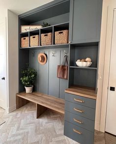 a room that has some shelves and drawers on the wall, with baskets in front of it