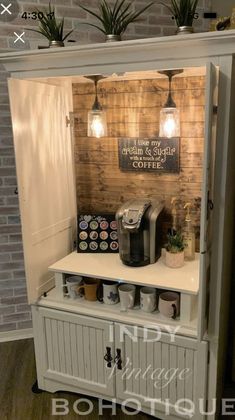 a coffee machine sitting on top of a white cabinet next to a wall with lights