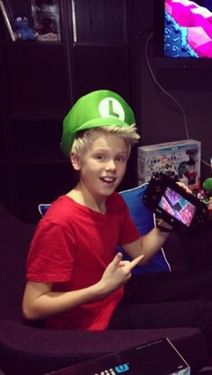 a young boy wearing a nintendo wii hat and holding a game controller in his hand