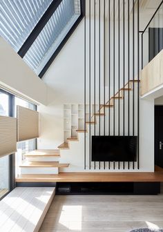 an image of a room with stairs and windows on the wall, as well as a tv in front of glass railings