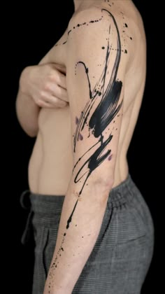 a man's arm with black ink and paint splattered on it, while he