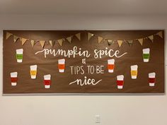 a bulletin board with cups and bunting hanging on it's side in a room