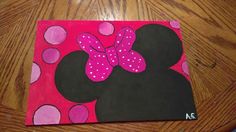 a minnie mouse painting on a wooden table with pink polka dots and a bow in the center