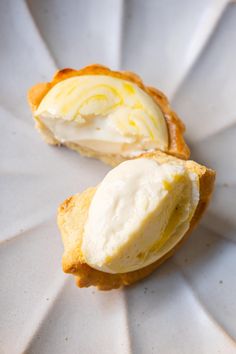 two pieces of pastry sitting on top of a white paper plate covered in icing