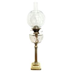 an old fashioned glass and brass lamp on a white background