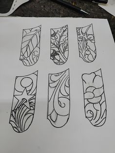 four different designs on a piece of paper with scissors next to it and some pens