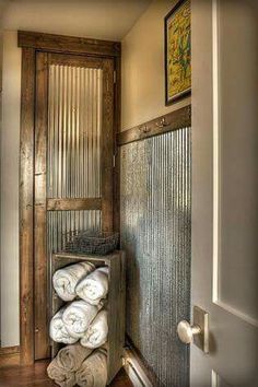 a bunch of towels are stacked up in a storage area next to a door and window