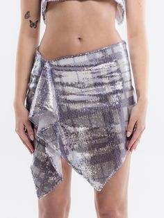 The Chiara mini skirt embodies ultra-feminine grunge. Upcycled from surplus designer fabric, the Chiara skirt is crafted from a plaid sequin mesh and lined with a soft jersey fabric. It features a high-low waist and an asymmetric hemline that showcases its effortlessly fluid drape. Ready to dazzle from sunset to sunrise! 88% Polyester; 12% Spandex Sequin embellished Mini skirt Asymmetric waistline & front hemline Draped cascading detail Invisible side zip closure Dry clean only Made in the Unite Summer Metallic Sequin Skirt, Stretch Draped Skirt For Spring Party, Contrast Sequin Summer Skirt, Summer Skirt With Contrast Sequin, Contrast Sequin Skirt For Summer, Spring Party Stretch Draped Skirt, Spring Party Draped Stretch Skirt, Glamorous Asymmetrical Party Skirt, Metallic Skirt For Summer Evenings