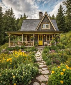 a small house in the woods surrounded by flowers and greenery with a yellow door