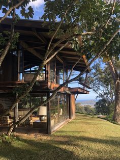 a wooden house sitting on top of a lush green field