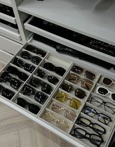 a drawer with many pairs of glasses in it