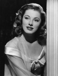 an old black and white photo of a woman leaning against a column with her eyes closed