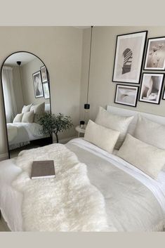 a bedroom with a bed, mirror and pictures on the wall in front of it