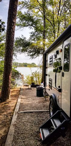 a camper parked on the side of a road next to a body of water