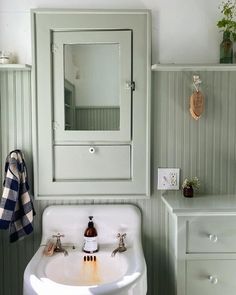 a white sink sitting under a bathroom mirror