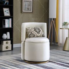 a white chair sitting on top of a rug next to a book shelf