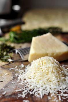 grated cheese on a wooden cutting board with other ingredients