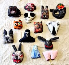 many different masks are arranged on a white sheet and one is painted black, the other has red