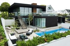 an aerial view of a house with a swimming pool and patio furniture in the foreground