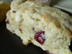 two scones sitting on top of a plate next to each other with cranberry toppings