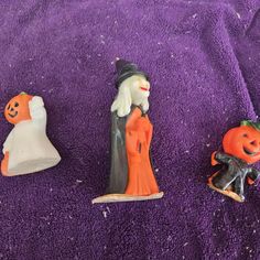 three halloween figurines sitting on a purple towel