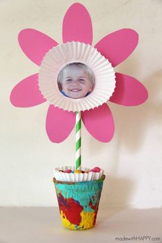 a flower that is sitting on top of a pot with a paper straw in it