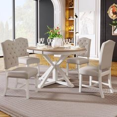 a dining room table with chairs around it and a rug in front of the table