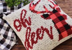 a crocheted pillow with the word merry written in red and black on it