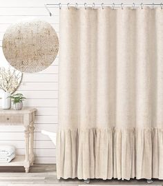 a shower curtain with a ruffled edge in front of a white wall and wooden floor