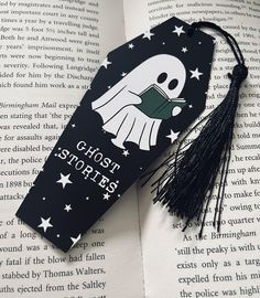 a bookmark with a ghost on it sitting on top of an open book,