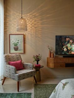 a living room with a chair, table and television on the wall in front of it